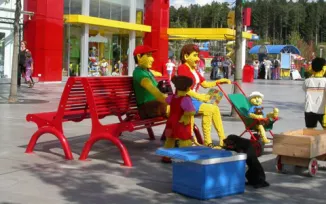 Legofiguren sitzen auf roter Parkbank Colorance von Runge