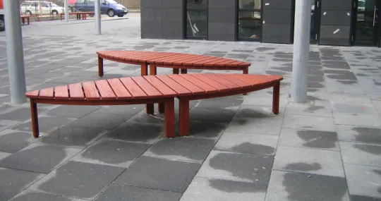 Board vor Eingang zum Bankgebäude als öffentliche Sitz- und Liegefläche Skulptur-ähnliche Großbänke