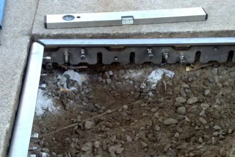 Winkel zur Befestigung des BOS Baumschutzes von Runge an den das Baumfeld umfassenden Granitplatten